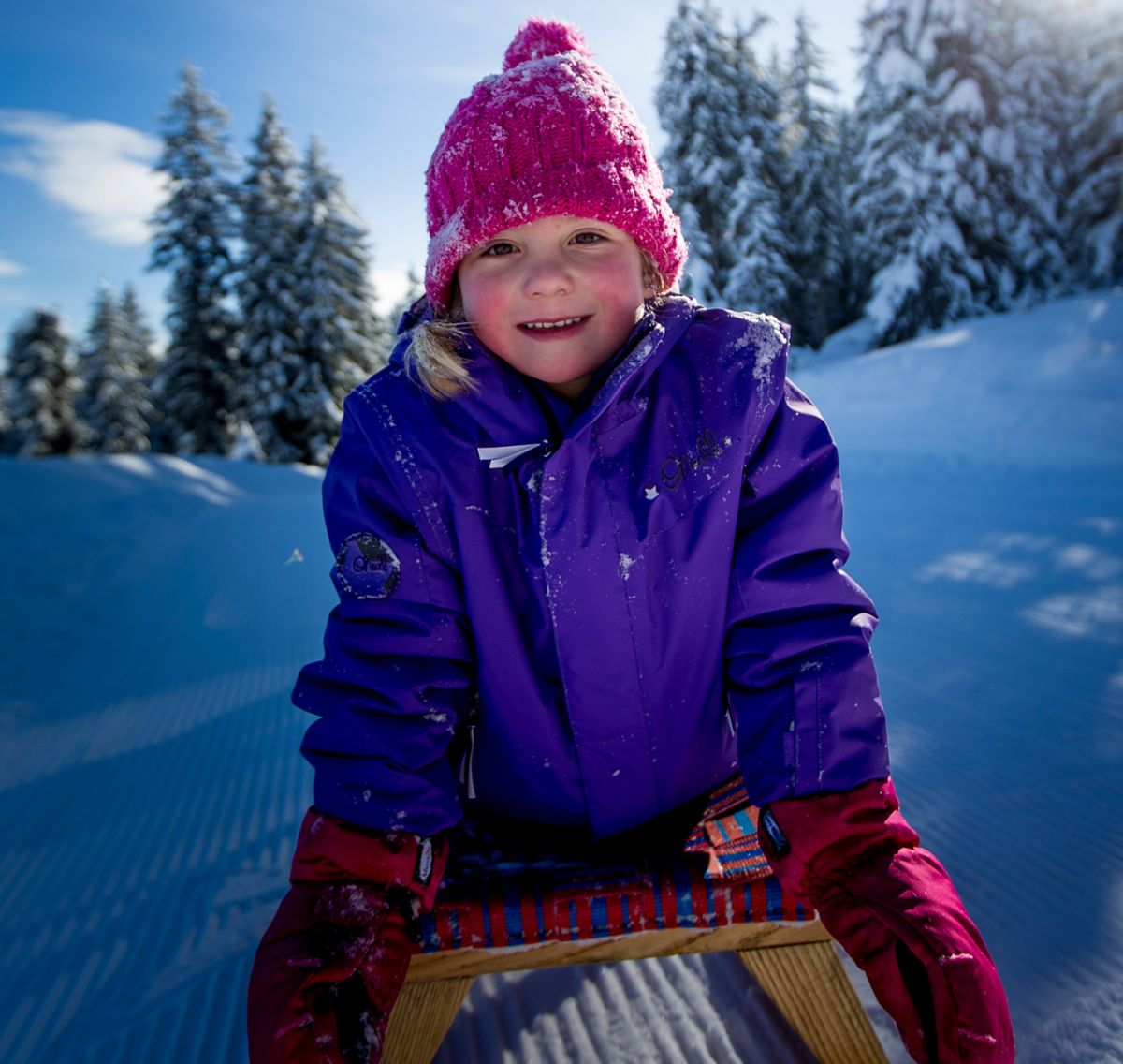 Kind auf Rodel hat Spaß bei Wintersport in Filzmoos
